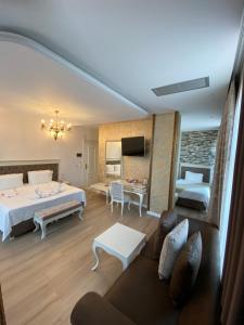 a bedroom with a bed and a living room at The Red Bricks Hotel in Shkodër