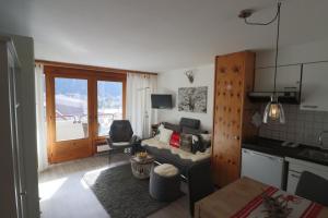 a small living room with a couch and a kitchen at Richmond - 303 in Davos