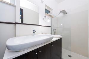 un bagno bianco con lavandino e doccia di The Pool House Suite a Sorrento
