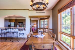 a dining room and kitchen with a wooden table and chairs at L'Équinoxe Rendez-Vous Mont-Tremblant in Mont-Tremblant