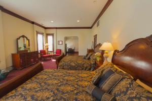 a hotel room with two beds and a mirror at Santa Paula Inn in Santa Paula