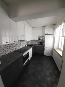 eine Küche mit weißen Schränken und einer schwarzen Arbeitsplatte in der Unterkunft Gasthaus Patruuna in Joutseno