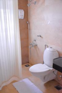 a bathroom with a toilet and a shower at LE Chalet - Serviced Luxury Condominium in Ahmedabad