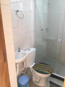 uma casa de banho com um WC, um chuveiro e um lavatório. em Pousada Alto de Junqueira em Mangaratiba