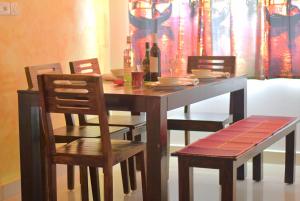 a dining room table and chairs with a wooden table and chairsktop at LE Chalet - Serviced Luxury Condominium in Ahmedabad