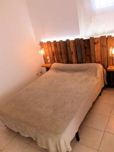 a bed in a room with a wooden wall at T3 VUE ETANG in Balaruc-les-Bains