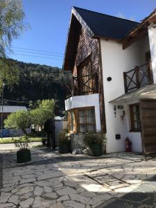 Casa blanca con ventanas y entrada de piedra en Holiday Home Las Retamas en San Martín de los Andes