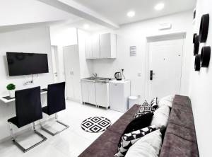 a living room with a couch and chairs and a tv at Apartments Monako in Herceg-Novi
