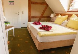 a bedroom with a bed with red flowers on it at Hotel Restaurant Mühlenhof Bosse in Dachwig