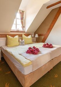 a bedroom with a large bed with red roses on it at Hotel Restaurant Mühlenhof Bosse in Dachwig