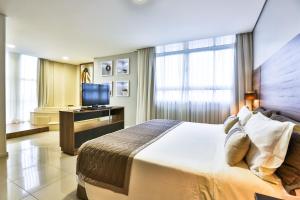 Postel nebo postele na pokoji v ubytování Wyndham Golden Foz Suítes