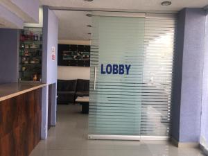 a lobby with a glass door with the logo on it at Hotel La Paz in Guadalajara