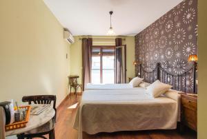 Un dormitorio con una cama grande y una mesa. en Hostal El Escudo de Mijas, en Mijas
