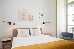 a bedroom with a white bed and a blue chair at Montebelo Lisbon Downtown Apartments in Lisbon