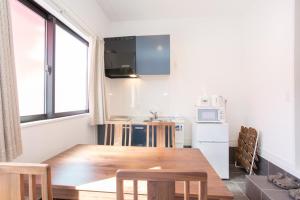 eine Küche mit einem Holztisch und eine Küche mit einem Fenster in der Unterkunft Kyomachiya Hatago Kujo / Vacation STAY 56006 in Kyoto