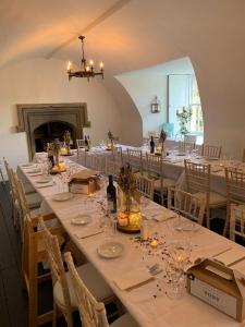 Branxholme Castle (Bed & Breakfast) في هاويك: غرفة طعام كبيرة مع طاولات وكراسي طويلة