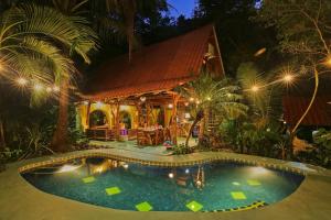uma piscina em frente a uma casa à noite em Nosara Sunrise Bed and Breakfast em Nosara