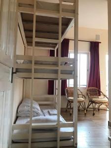a bunk bed in a room with two chairs and a bunk bed in a bedroom at Mone's Mountain View Hotel in Kāskī