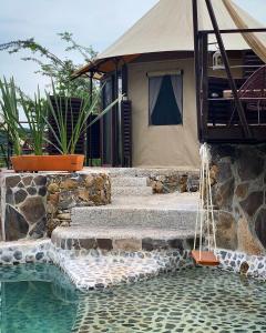 a house with stairs next to a swimming pool at Hostal de la Luz - Spa Holistic Resort in Tepoztlán