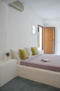 a bedroom with a bed with a book on it at George & Irene Hotel in Ios Chora