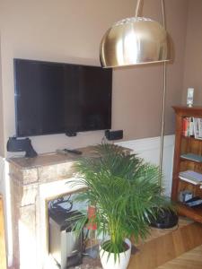 a living room with a fireplace with a flat screen tv at Gobelins in Paris