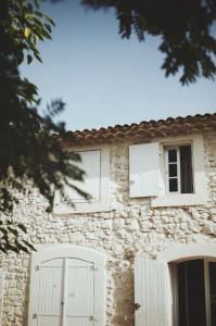 a stone house with white doors and windows at Domaine de Carraire in Aix-en-Provence