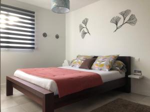 ein Schlafzimmer mit einem Bett mit einer roten Decke in der Unterkunft Villa Pignada in Lanton