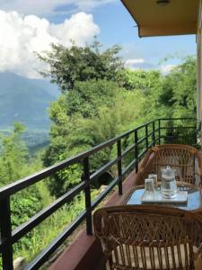einen Tisch und Stühle auf einem Balkon mit Aussicht in der Unterkunft Mone's Mountain View Hotel in Kāskī