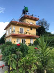 ein gelbes Haus mit einem grünen Turm darüber in der Unterkunft Mone's Mountain View Hotel in Kāskī