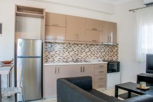 a kitchen with a refrigerator and a couch in a room at Jenny Apartments in Zakynthos Town