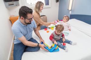 a man and two women and a child in a hospital room at ibis budget Curitiba Centro in Curitiba