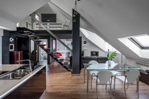 a kitchen and dining room with a glass table and a staircase at Oktheway Loft Maestranza in A Coruña