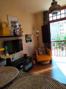 salon z telewizorem, krzesłem i oknem w obiekcie Apartamento La Peatonal w mieście San Sebastián de la Gomera