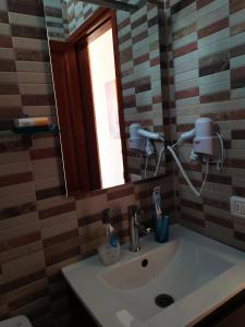 W łazience znajduje się umywalka z lustrem i okno. w obiekcie Apartamento La Peatonal w mieście San Sebastián de la Gomera