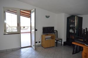 een kamer met een deur naar een kamer met een televisie bij Apartments Agostino in Ioppolo