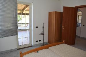 een slaapkamer met een bed en een glazen schuifdeur bij Apartments Agostino in Ioppolo