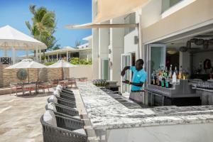 a man standing at a bar at a resort at Sea Breeze Beach House All Inclusive by Ocean Hotels in Christ Church