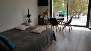 a bedroom with a bed and a table and chairs at gite A L' ÉVIDENCE in Mornas