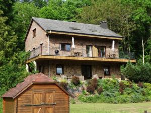 a large brick house with a balcony on top of it at Relais des Eveux in La Roche-en-Ardenne