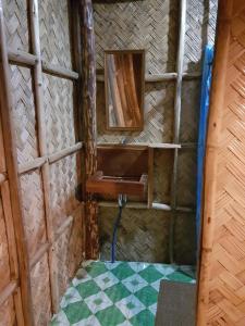 Habitación con pared con lavabo y suelo de baldosa. en Backpacker's Hill Resort en San Vicente