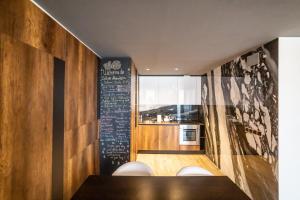 a kitchen with a table and a chalkboard on the wall at Floriday Luxury Apartment in Silver Mountain in Poiana Brasov