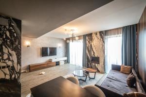 a living room with a couch and a table at Floriday Luxury Apartment in Silver Mountain in Poiana Brasov