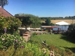 a boat in a yard next to a lake at Onze Logeerkamer in Deil