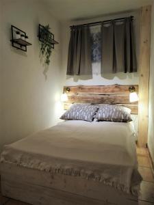 a bedroom with a bed with a wooden headboard at Studio Eveux in La-Roche-en-Ardenne