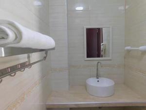 Baño blanco con lavabo y espejo en Sunshine Hotel en Lima