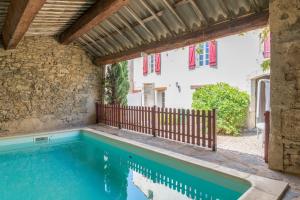 una piscina all'aperto con recinzione in legno e una casa di Familien Resort Haus a Armissan