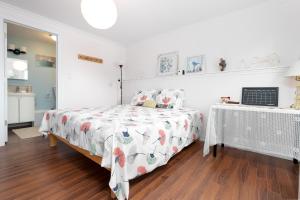 ein weißes Schlafzimmer mit einem Bett und einem Tisch in der Unterkunft Lily's garden in Charlottetown