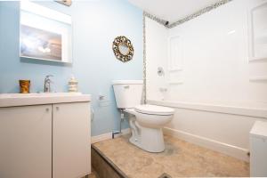 a bathroom with a toilet and a tub and a sink at Lily's garden in Charlottetown +65 photos