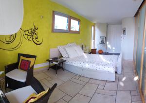 een slaapkamer met een wit bed en een gele muur bij A l Ombre des Catalpas in Bischwihr