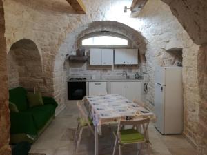 a kitchen with a table in a stone wall at Trulli Manuela 2 in Locorotondo